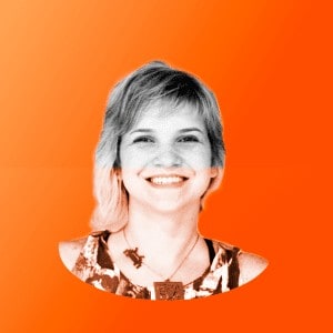 Uma mulher sorrindo diante de um fundo laranja.