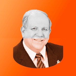Um homem de terno e gravata está sorrindo em um fundo laranja.