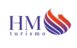 Logotipo da HM Turismo com as iniciais estilizadas "HM" e a palavra "turismo" abaixo, ao lado de um globo vermelho e roxo com uma seta ao redor.